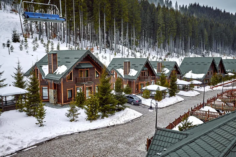 Row of snowy cabins at the base of a ski slope