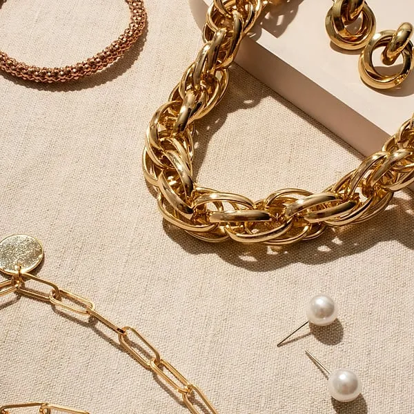 Gold and pearl jewelry laid out on linen