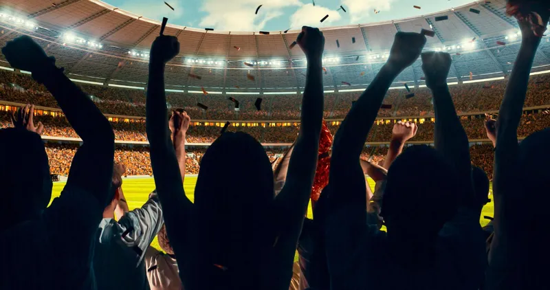 Crowd celebrating with arms raised and confetti falling