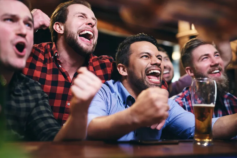 Friends cheering together around a screen