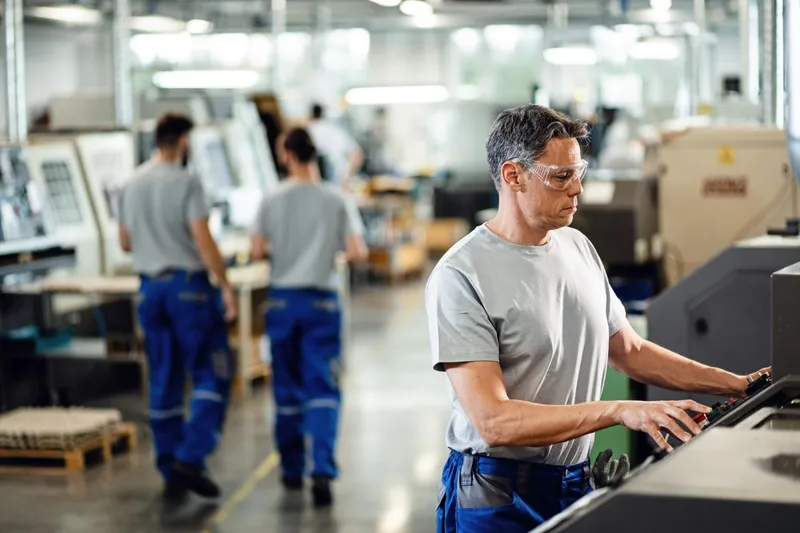 Machine operators working the floor of a manufacturing plant